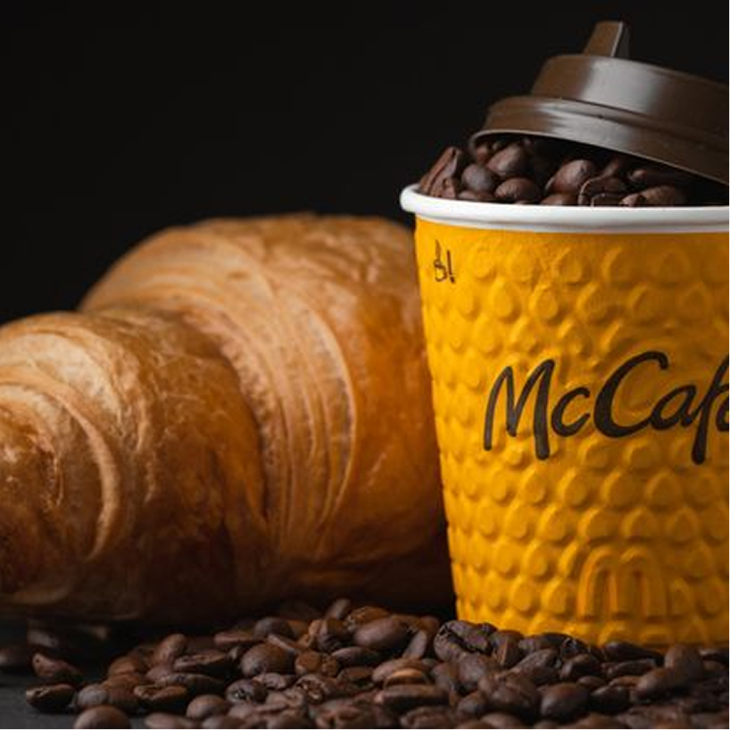 Croissant and McCafe cup with roasted coffee beans
