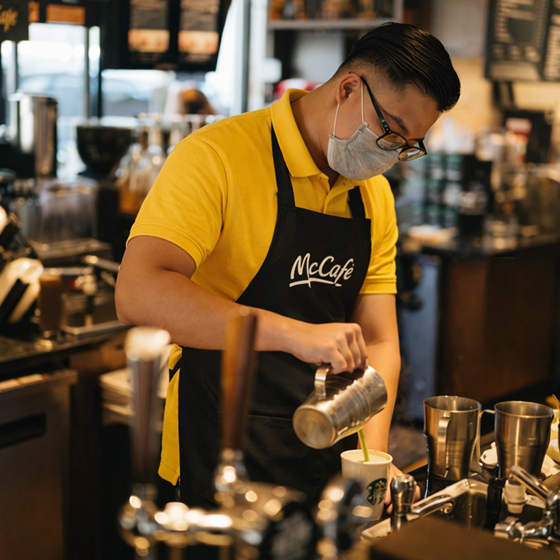 McCafe barista steaming milk at the espresso machine